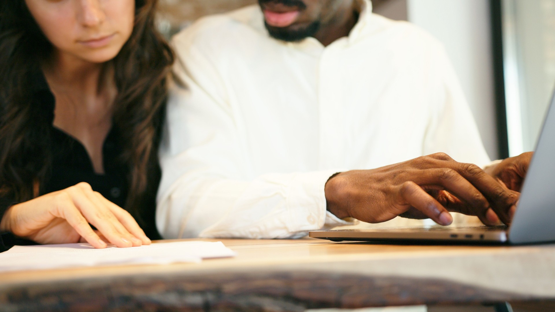 Affectionate mixed race couple going through paperwork. African man and latin woman calculating bills