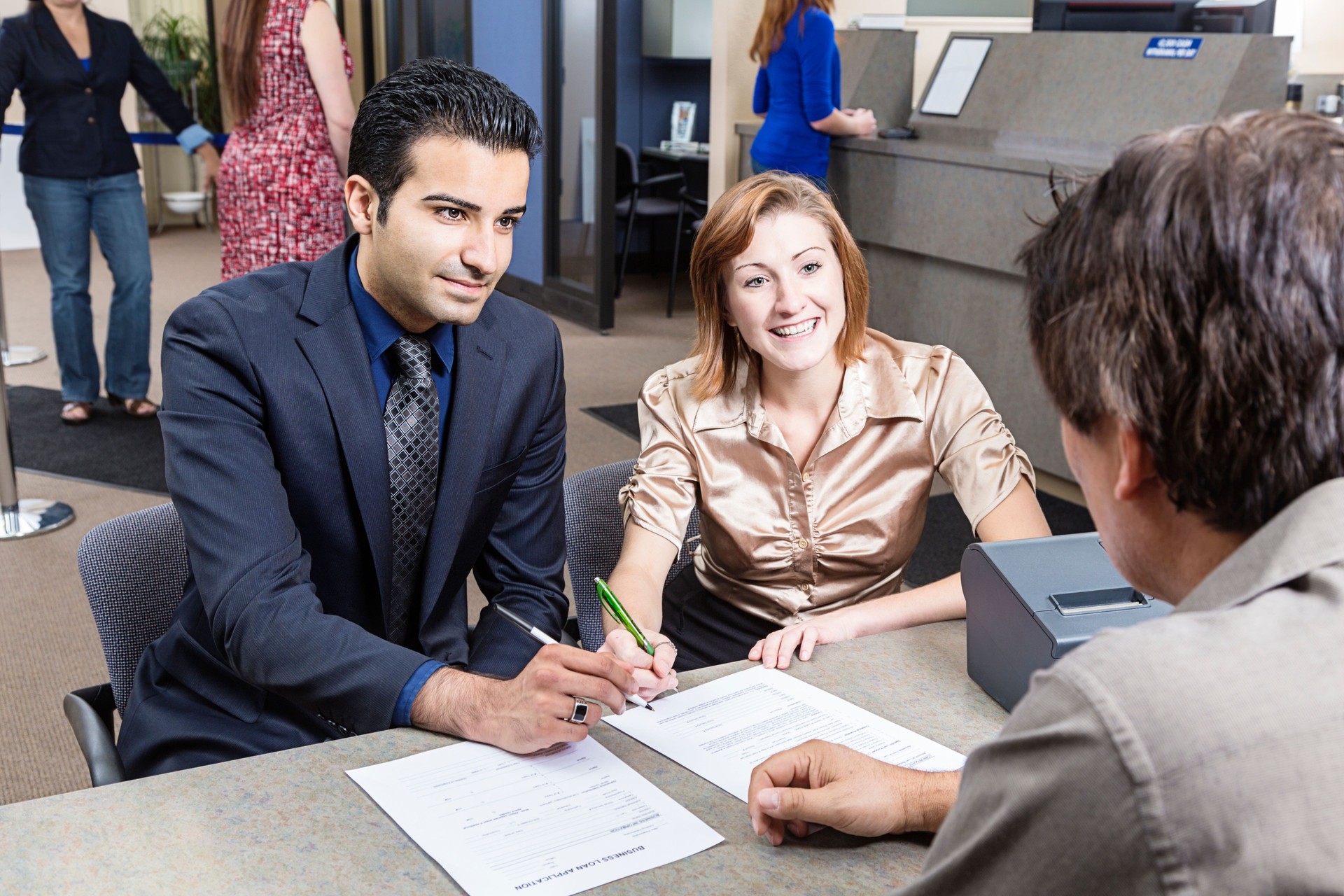 Couple Looking at Application With Banker